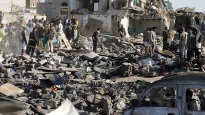 People looking through wreckage