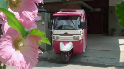 The pink and white auto-rickshaw
