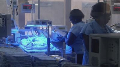 A maternity ward, with a baby in an incubator