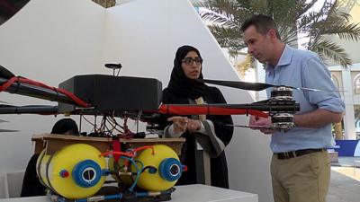 Sameera A. Almulla, Khalifa University stands next to a drone which can disperse fog