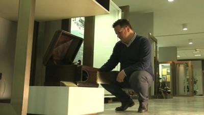 Man looking at gramophone