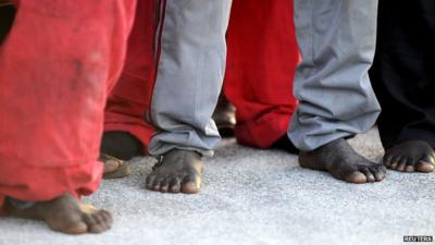 Close up of the bare feet of migrants who have arrived in Sicily