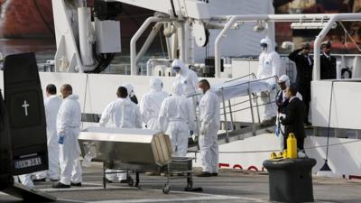 Italian coastguards carry a body from their ship in Malta