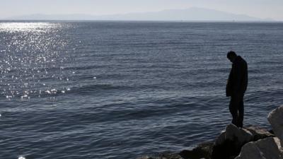 Man stands on sea shore