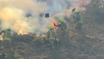 Firefighters batting down the flames