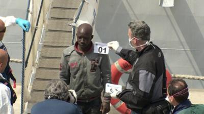 A migrant being processed at the port