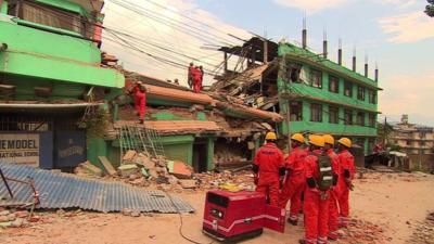 Rescue workers in front of a collapsed building