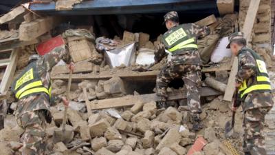 Police search ruins after a 7.9-magnitude earthquake hit Nepal