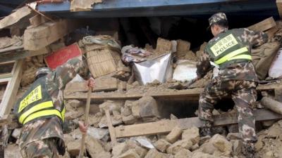 Police search ruins after a 7.9-magnitude earthquake hit Nepal