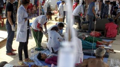 Earthquake victims receive medical treatment outside the overcrowded Dhading hospital