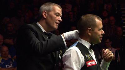 Referee Jan Vass assists Hawkins with his bow tie