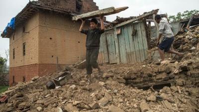 Nepalese boys searching among earthquake rubble