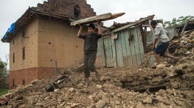 Nepalese boys searching among earthquake rubble