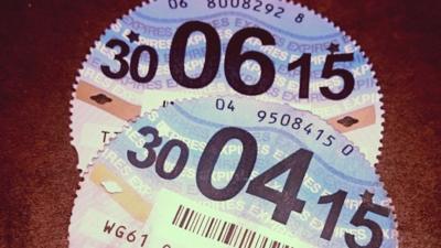 Close up of two tax discs (with expiry dates in June and April 2015)