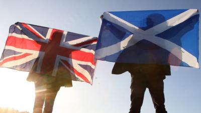 Scottish and English flags held up over Edinburgh, Scotland