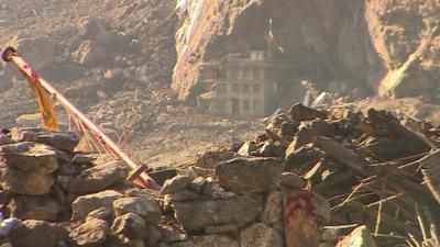 Rubble in Langtang with remains of only building still standing in background