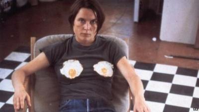 Sarah Lucas sitting with two fried eggs on her chest