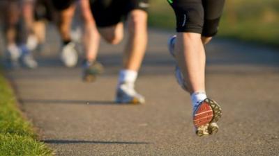 legs of members of a running club in motion