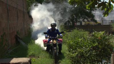 A motorbike with insecticide being sprayed from the back