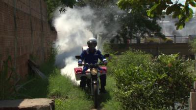 A motorbike with insecticide being sprayed from the back