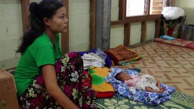 Lady sits next her baby