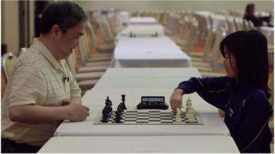 Carissa Yip and her dad play chess