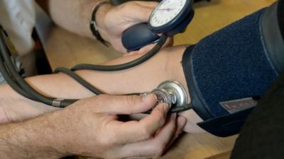 Doctor taking patient's blood pressure