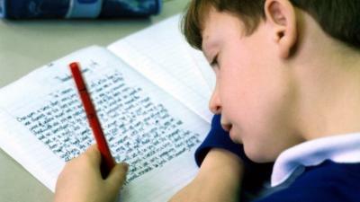 Child writing in book