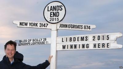 File photo of Nick Clegg standing in front of sign in Land's End, Cornwall which has been amended to read: "LibDems 2015, Winning here"