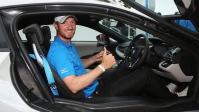 Golfer Chris Wood poses after winning a car for a hole-in-one at the PGA Championship at Wentworth