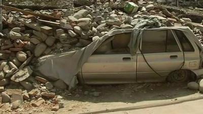 Damaged car covered in debris from Nepal earthquake