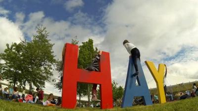 Hay letters with children playing in a field