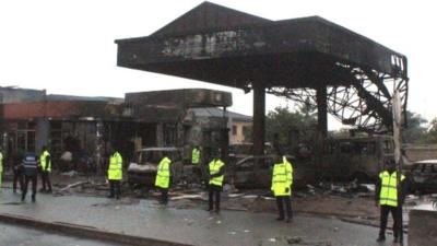 Policemen stand guard as rescuers work on the site of a petrol station fire in Ghana"s capital, Accra,