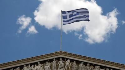 Greek flag on top of Athens Academy building