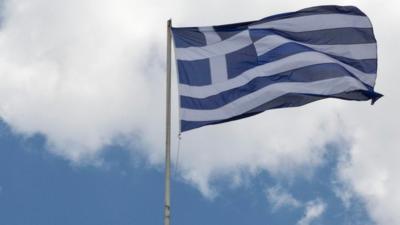 Greek flag on top of Athens Academy building