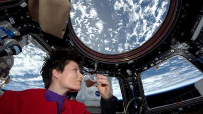 Italian astronaut Samantha Cristoforetti sips espresso from a cup designed for use in zero-gravity, on the International Space Station.
