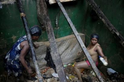 Dos mujeres recuperan sus pertenencias luego de que su vivienda quedara destruida.