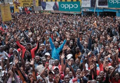Kenyans watch a big screen on October 12, 2019, in Nairobi as they celebrate Kenya's Eliud Kipchoge victory. - Kenya's Eliud Kipchoge, on October 12, 2019, made history, busting the mythical two-hour barrier for the marathon on a specially prepared course in a huge Vienna park. With an unofficial time of 1hr 59min 40.2sec, the Olympic champion became the first ever to run a marathon in under two hours in the Prater park with the course readied to make it as even as possible. (Photo by Yasuyoshi CHIBA / AFP) (Photo by YASUYOSHI CHIBA/AFP via Getty Images)