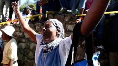 Una mujer reacciona con una expresión de dolor en el lugar donde se incendió el orfanato.