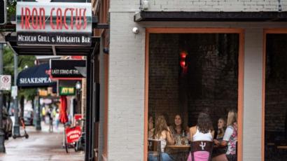 Foto de fachada de um restaurante no Texas, onde pessoas sentadas conversam