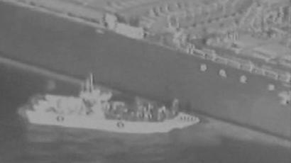 صور نشرها الجيش الأمريكي لما يقول إنه قارب دورية بحرية من الحرس الثوري الإيراني تزيل لغما غير منفجر ملصق بواحدة من الناقلتين