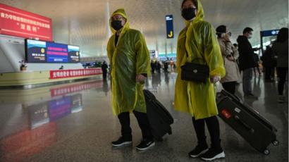 Passengers wearing protective gear walk at the Tianhe Airport after it was reopened today, in Wuhan in China's central Hubei province on April 8, 2020.