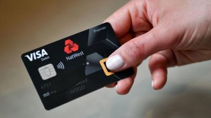An employee poses with UK's first biometric fingerprint debit card during a photocall at Natwest offices in central London on April 24, 2019.