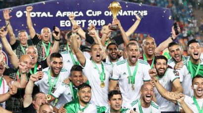 اللاعب رياض محرز يحمل كأس البطولة وسط فريق الجزائر المحتفي بفوزه للمرة الثانية بكأس الأمم الأفريقية