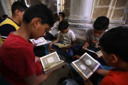 أطفال مسلمون في غزة يقرأون آيات قرآنية في أول أيام رمضان في جامع العمري في غزة. 06 مايو/أيار 2019