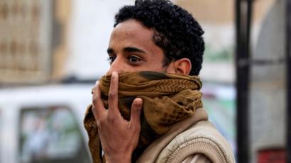 يمني يغطي فمه وأنفه بالغترة أو الشال اليمني