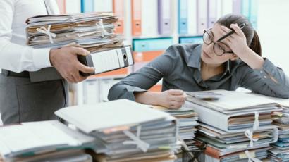 Mujer en su escritorio lleno de papeles