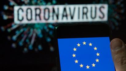 Dans cette illustration photo, le logo du drapeau de l'Union européenne est affiché sur un smartphone avec un modèle informatique du coronavirus COVID-19 en arrière-plan.