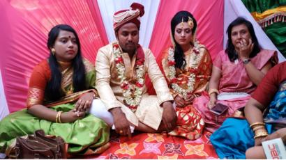 বিয়ে বাড়ির অতিথিদের সঙ্গে বর কনে।