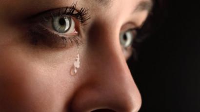 Le visage d'une femme avec une larme sur la joue